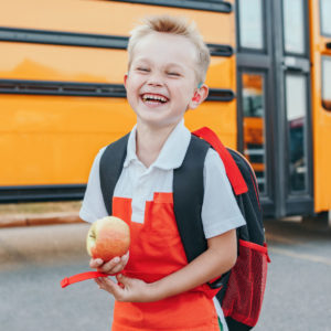 child in front of school bus